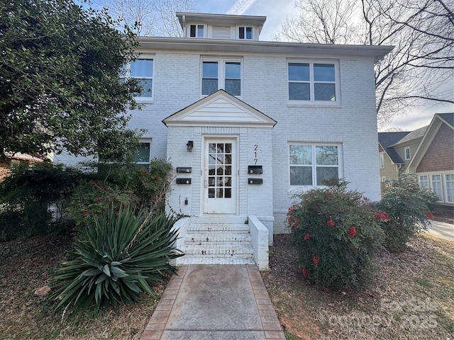 american foursquare style home with entry steps and brick siding