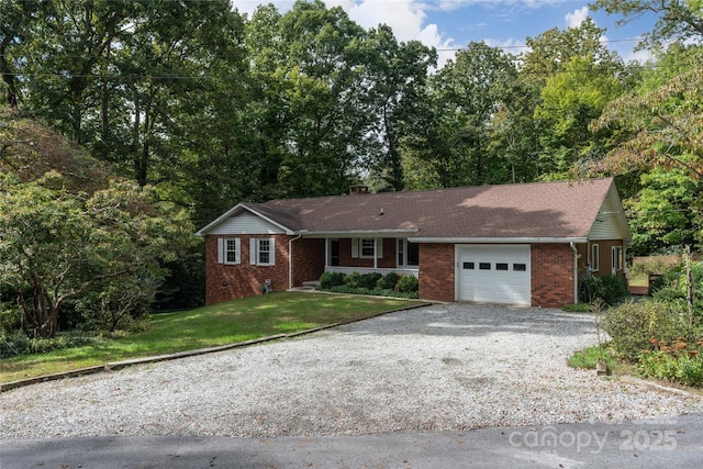 ranch-style house with a garage, brick siding, a shingled roof, driveway, and a front yard