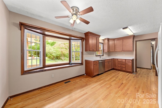 kitchen featuring light wood-style flooring, visible vents, baseboards, light countertops, and dishwasher