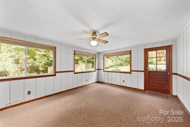 unfurnished sunroom featuring a wealth of natural light and a ceiling fan