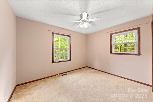 unfurnished room featuring a ceiling fan, a textured ceiling, baseboards, and carpet flooring