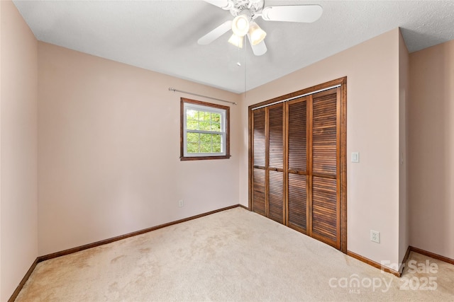 unfurnished bedroom with a closet, carpet, a ceiling fan, and baseboards