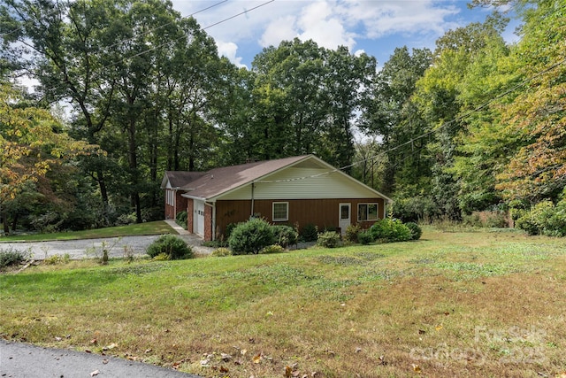 view of front of property featuring driveway, an attached garage, and a front yard