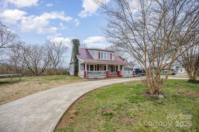 view of front facade with driveway, a front lawn, a trampoline, a porch, and a chimney