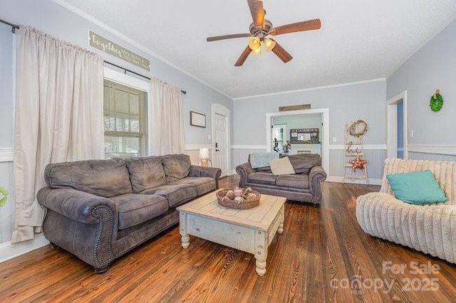 living room featuring a ceiling fan, crown molding, wood finished floors, and wainscoting