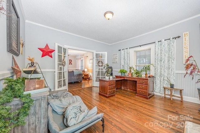 office area featuring crown molding, wainscoting, french doors, wood finished floors, and a textured ceiling