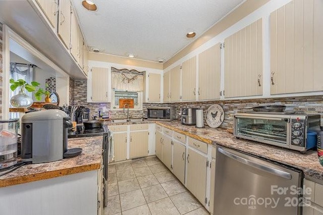 kitchen with a toaster, light tile patterned flooring, light countertops, appliances with stainless steel finishes, and backsplash