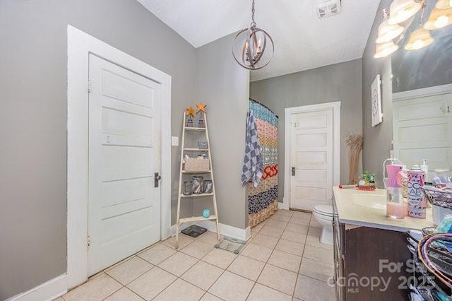 foyer with visible vents, baseboards, a notable chandelier, and light tile patterned flooring