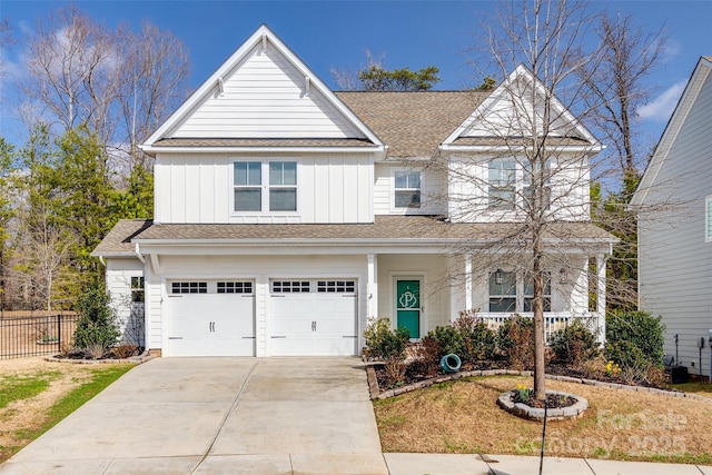 view of front of house with covered porch, an attached garage, board and batten siding, fence, and driveway