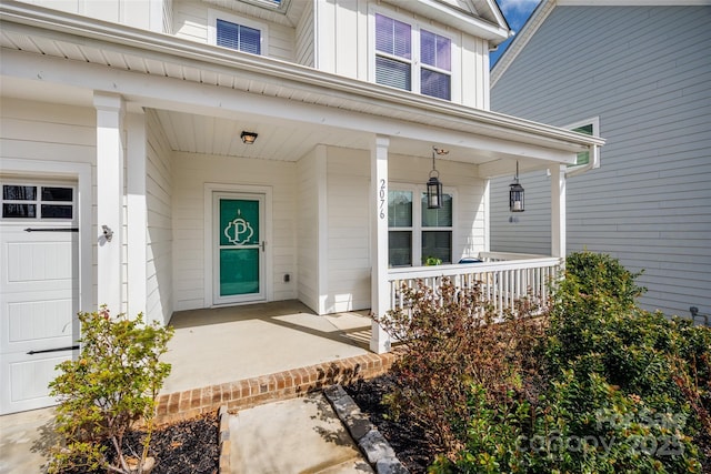 property entrance with a garage, a porch, and board and batten siding