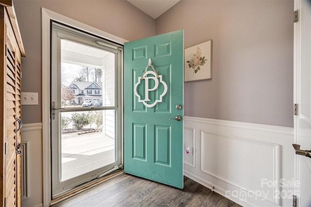 entryway with wood finished floors and wainscoting