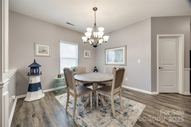 dining room with dark wood finished floors, visible vents, a notable chandelier, and baseboards