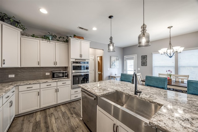 kitchen featuring stainless steel appliances, a sink, dark wood finished floors, and white cabinets