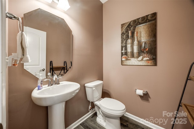 bathroom featuring wood finished floors, toilet, and baseboards