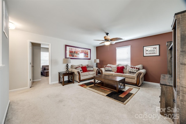 living room with ceiling fan, carpet flooring, and baseboards