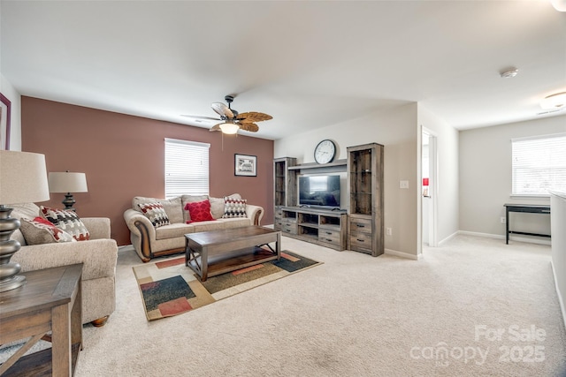 living room featuring light carpet, a ceiling fan, and baseboards