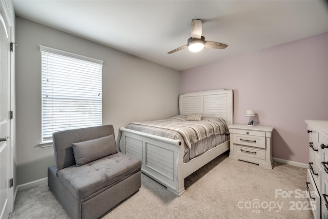 bedroom featuring ceiling fan, light carpet, and baseboards