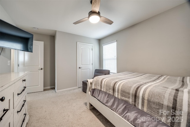 bedroom featuring a ceiling fan, light carpet, and baseboards