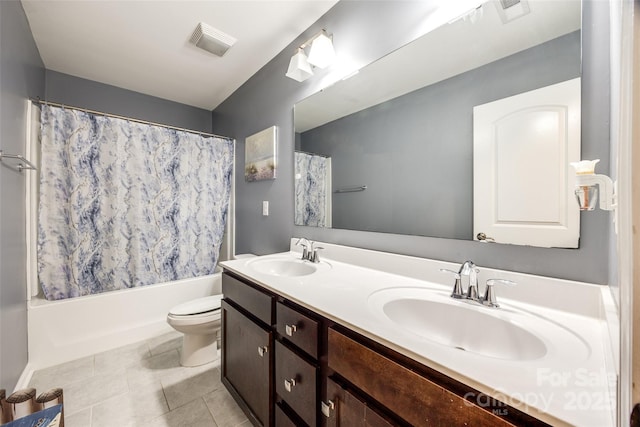 full bathroom with toilet, double vanity, visible vents, and a sink