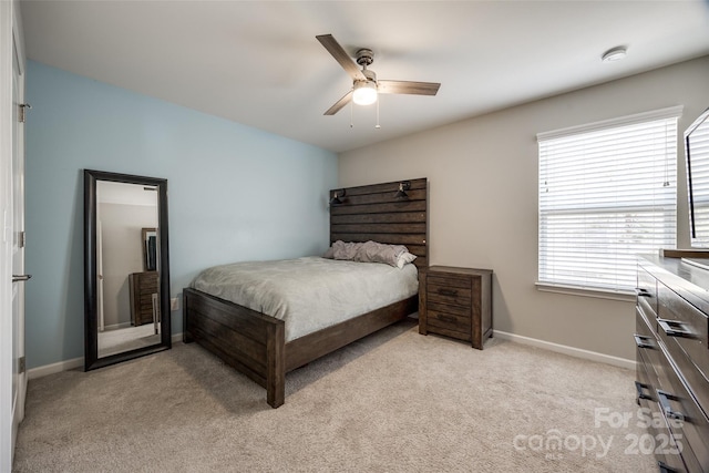 bedroom featuring baseboards, a ceiling fan, and light colored carpet