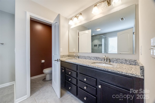 full bathroom featuring double vanity, a sink, toilet, and tile patterned floors