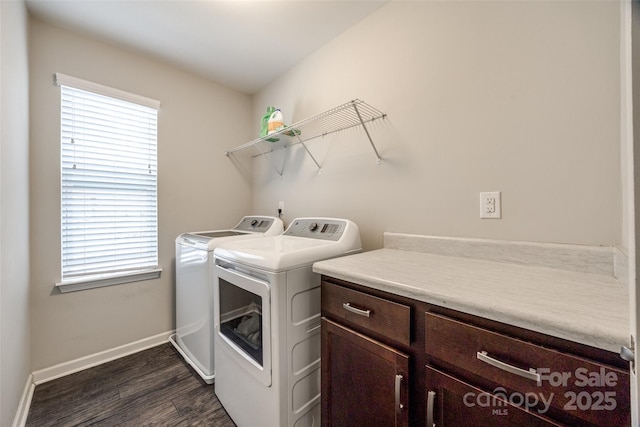 laundry area with dark wood-style flooring, washing machine and dryer, a wealth of natural light, and baseboards