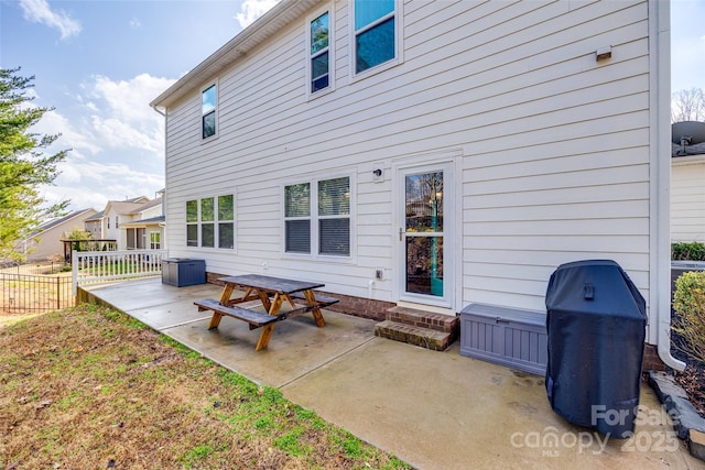 rear view of property featuring a patio and fence