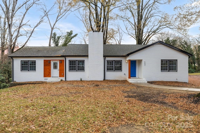 ranch-style house featuring entry steps, brick siding, and a chimney