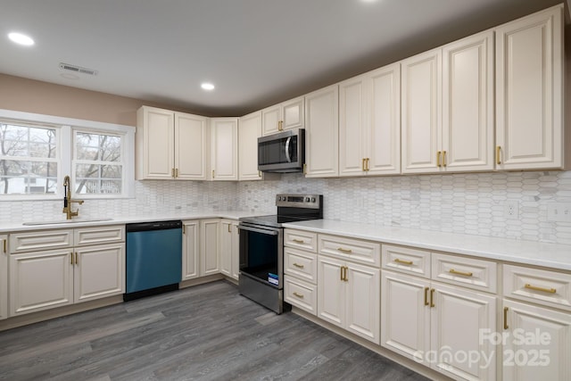 kitchen with recessed lighting, dark wood-style flooring, a sink, visible vents, and appliances with stainless steel finishes