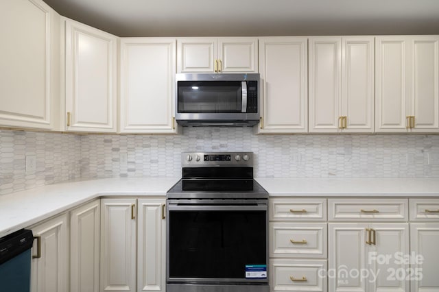 kitchen featuring appliances with stainless steel finishes, white cabinets, decorative backsplash, and light countertops