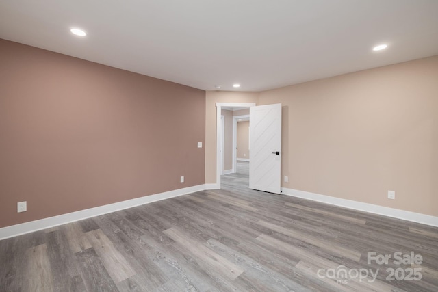 empty room featuring recessed lighting, wood finished floors, and baseboards