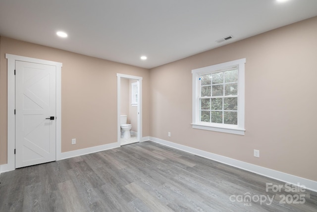 spare room with recessed lighting, wood finished floors, visible vents, and baseboards