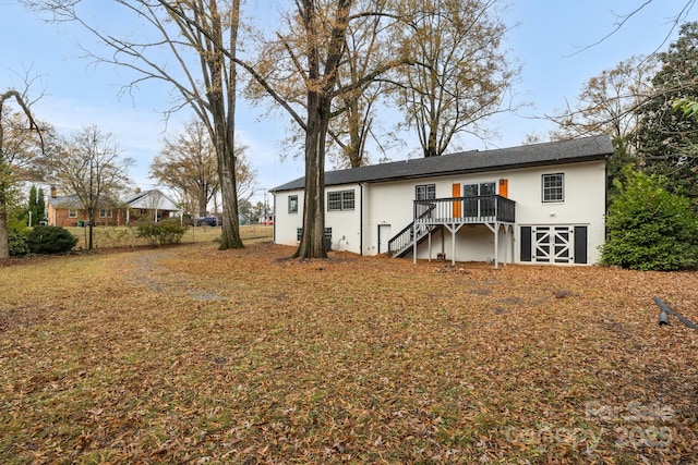 back of property featuring stairs and a deck