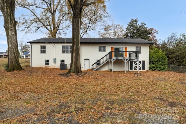 rear view of house with central air condition unit, a wooden deck, and stairs