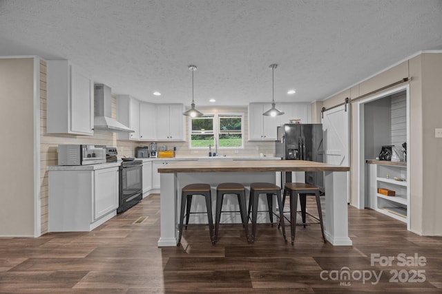 11 Pyrite Way, Asheville, NC 28806 - kitchen with black appliances, wall chimney exhaust hood, wood counters, a barn door, and white cabinetry