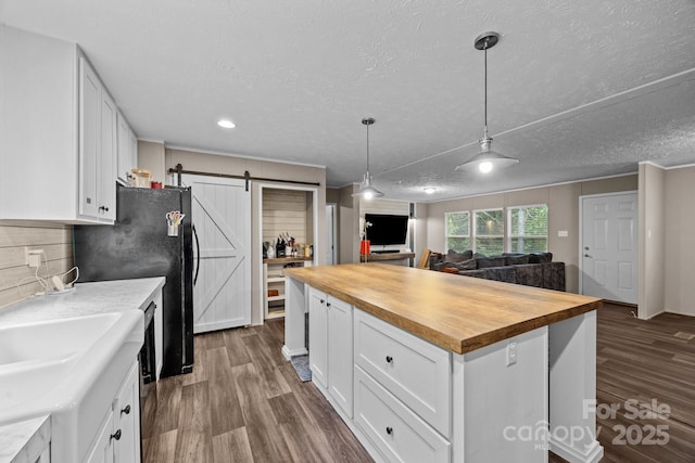11 Pyrite Way, Asheville, NC 28806 - kitchen with butcher block counters, a barn door, open floor plan, white cabinetry, and dark wood finished floors