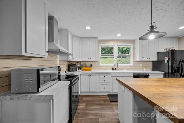 11 Pyrite Way, Asheville, NC 28806 - kitchen featuring wall chimney range hood, black appliances, butcher block countertops, dark wood-style flooring, and white cabinets