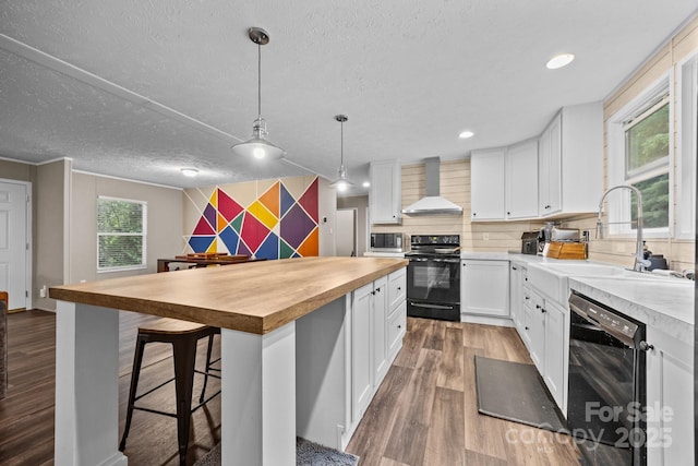 11 Pyrite Way, Asheville, NC 28806 - kitchen with black appliances, wall chimney range hood, butcher block countertops, a sink, and wood finished floors
