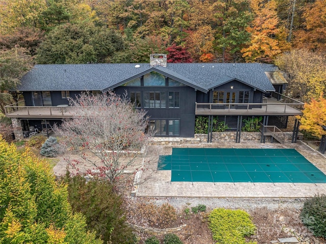 view of pool featuring a deck, a patio, stairway, and a covered pool