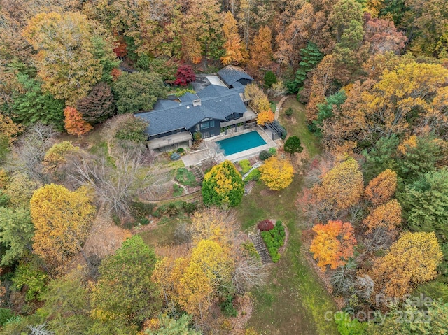 drone / aerial view with a wooded view