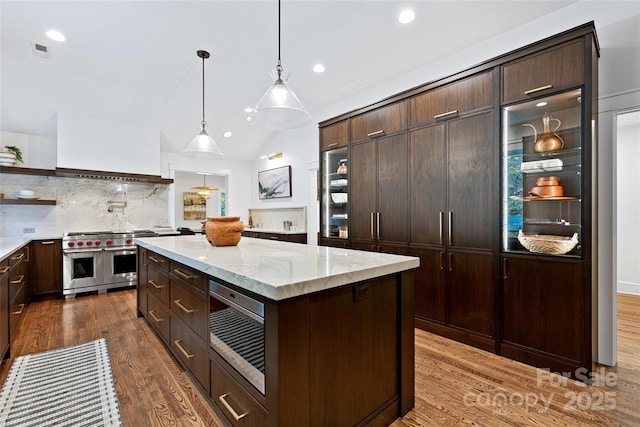 kitchen with range with two ovens, custom exhaust hood, open shelves, visible vents, and dark brown cabinets