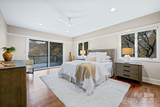 bedroom with access to exterior, multiple windows, and wood finished floors