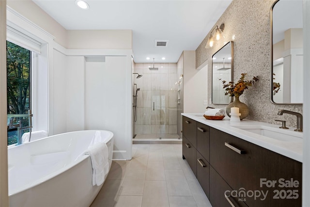 full bath with double vanity, backsplash, a stall shower, a sink, and a freestanding tub