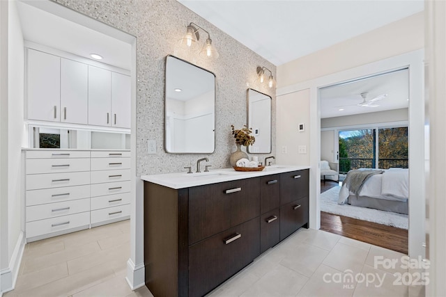 ensuite bathroom with double vanity, tile patterned floors, a sink, and ensuite bathroom