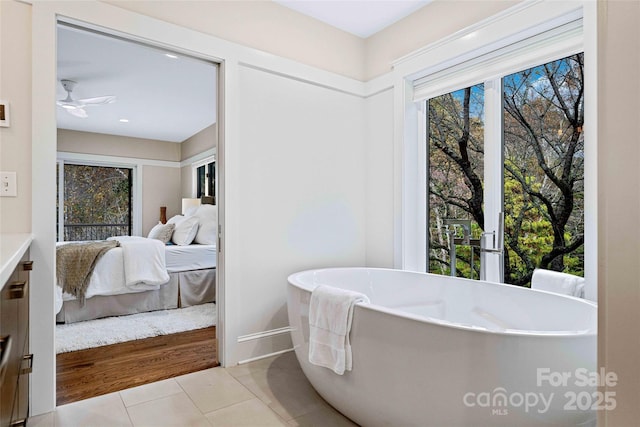 ensuite bathroom featuring ceiling fan, tile patterned floors, a freestanding bath, and ensuite bathroom