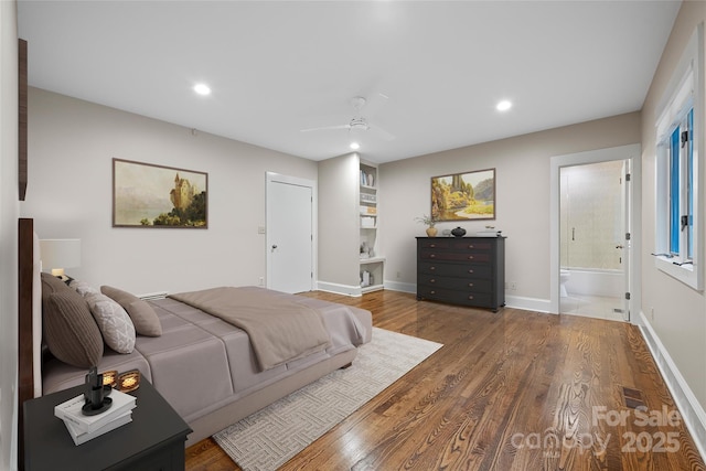 bedroom with connected bathroom, baseboards, wood finished floors, and recessed lighting