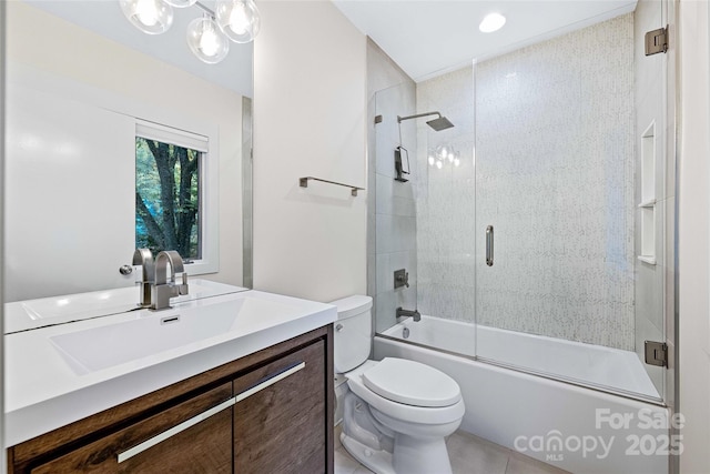 bathroom featuring enclosed tub / shower combo, vanity, and toilet