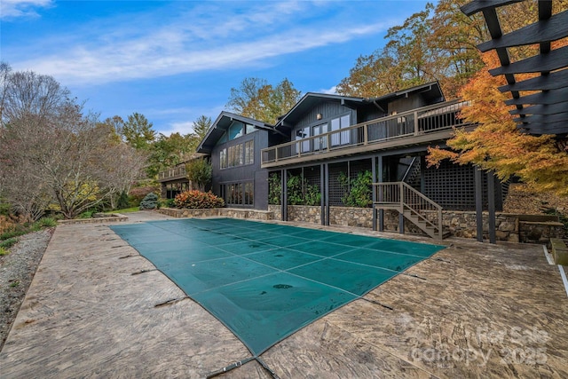 view of swimming pool with a patio, stairway, a wooden deck, and a covered pool