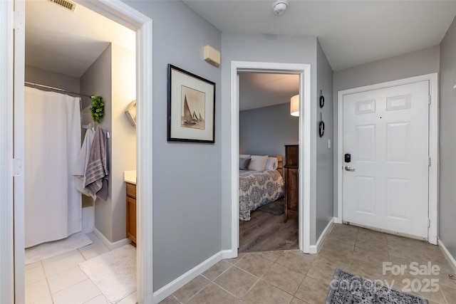 hallway featuring light tile patterned floors and baseboards