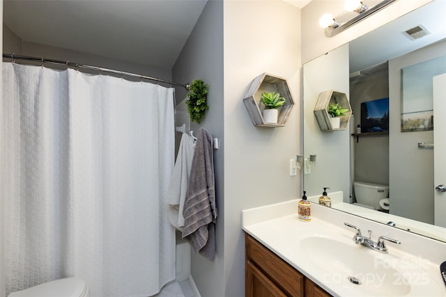 bathroom featuring visible vents, vanity, and toilet